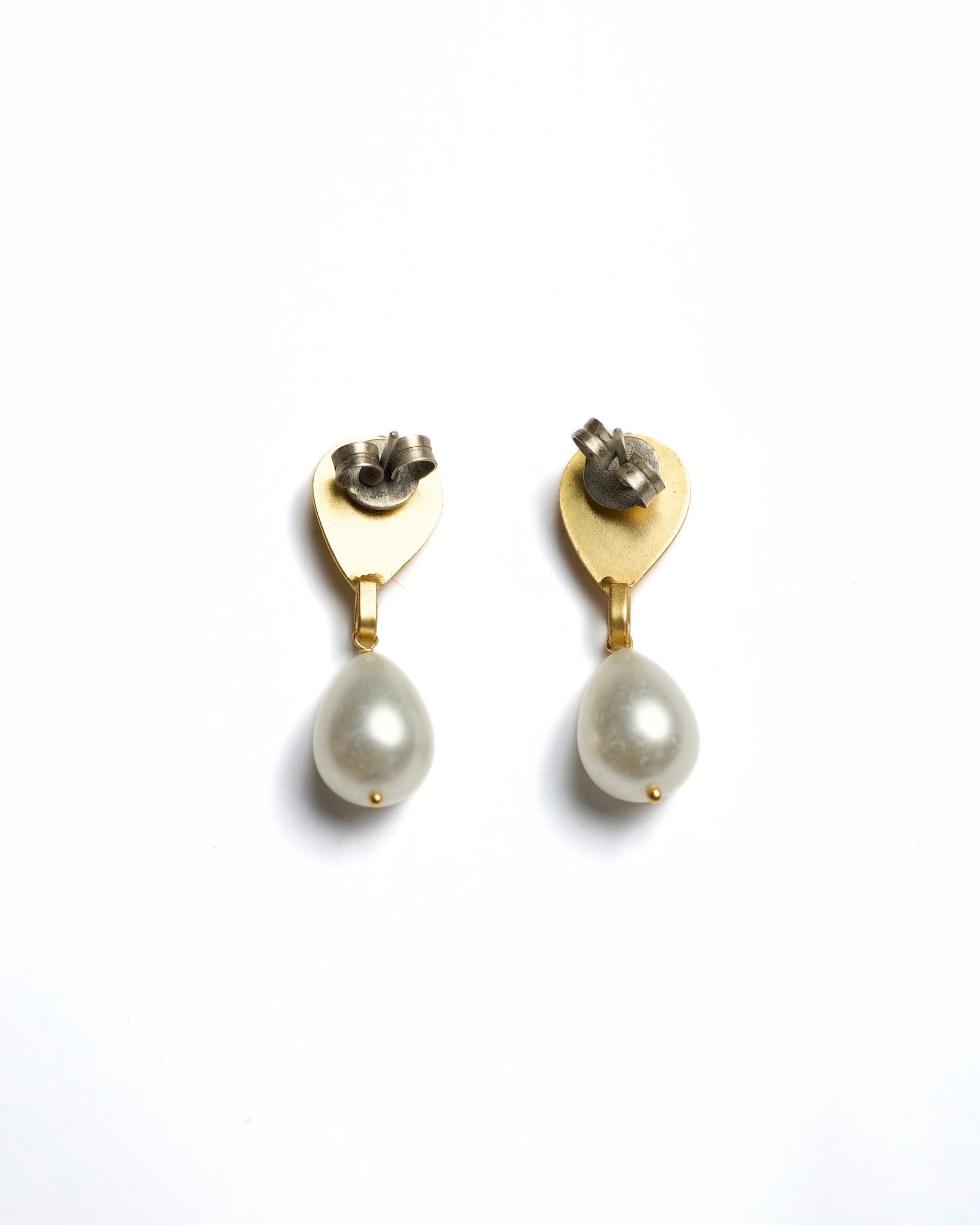 Close-up of gold-polished 925 silver drop earrings featuring a faceted clear stone stud and a suspended white teardrop pearl.