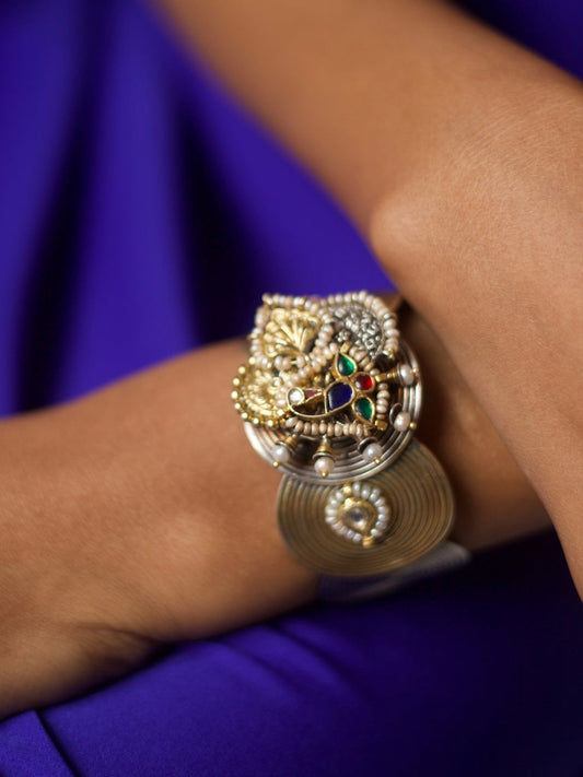 Handcrafted silver cuff with spiral base, navratna enamel, and sculptural motifs in 92.5 silver by Naksa