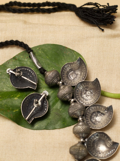 Temple Ambi Set by Naksa—oxidized 925 silver necklace and stud earrings with paisley motifs and wine-red accents.
