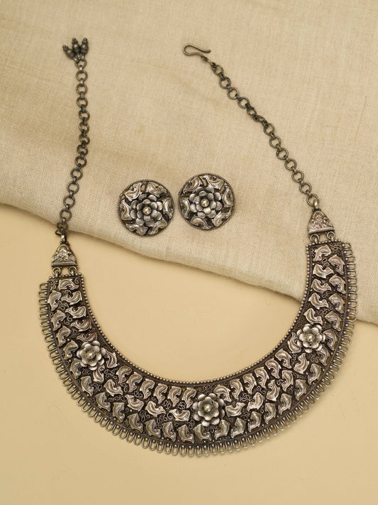 Jalrupi Haar by Naksa—oxidized 925 silver crescent necklace with fish and floral motifs, paired with round floral stud earrings.