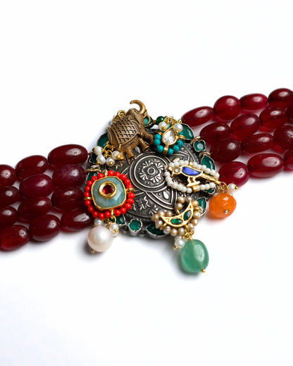 925 silver oxidised statement choker with red oval beads, elephant charm, bird motif, pearl drops, green and orange stone accents, and gold polish detailing.