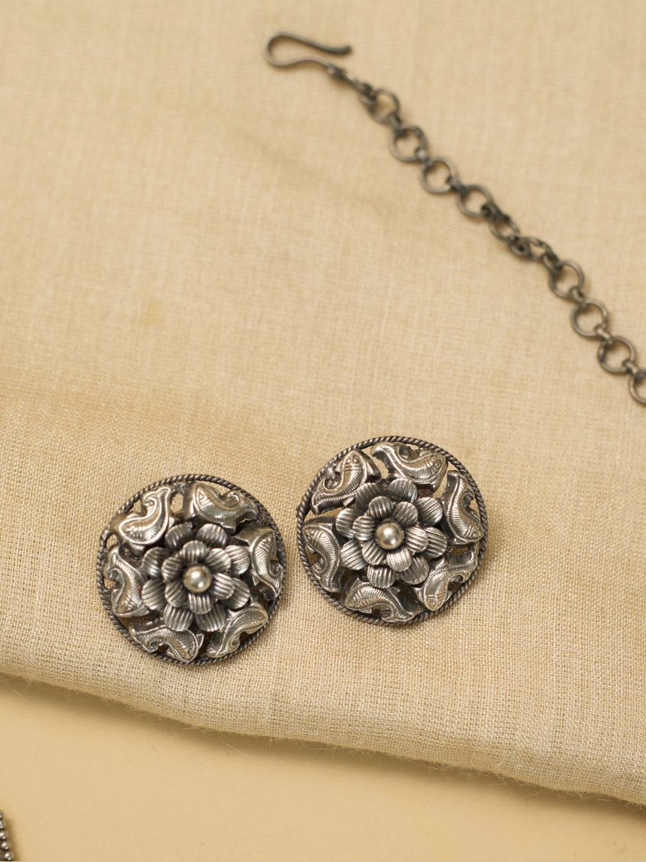 alrupi Haar by Naksa—oxidized 925 silver crescent necklace with fish and floral motifs, paired with round floral stud earrings.