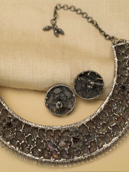 Jalrupi Haar by Naksa—oxidized 925 silver crescent necklace with fish and floral motifs, paired with round floral stud earrings.