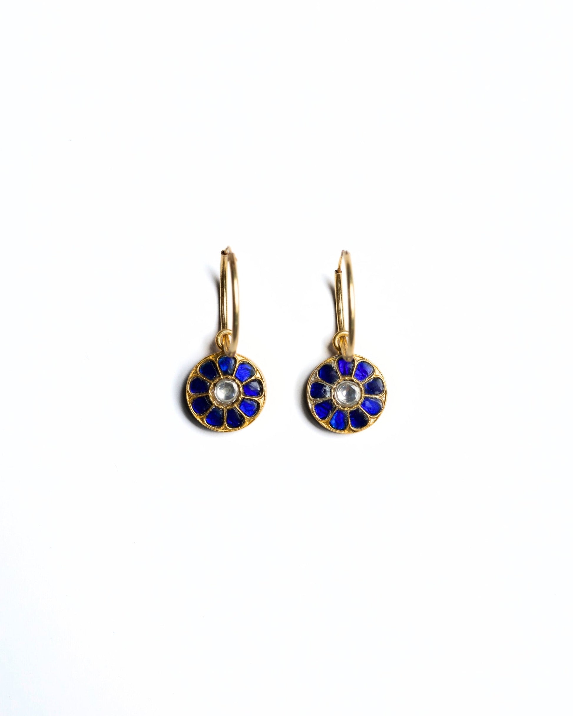 Close-up of small gold-polished 925 silver hoop earrings with deep blue lapis-style petal inlay and kundan stone centre.
