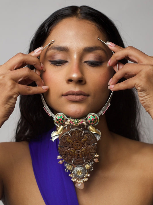 Handcrafted 92.5 silver hasli necklace featuring dark carved animal motif, enamel detailing, pearls, elephants, and fusion gold-polished accents, styled on model