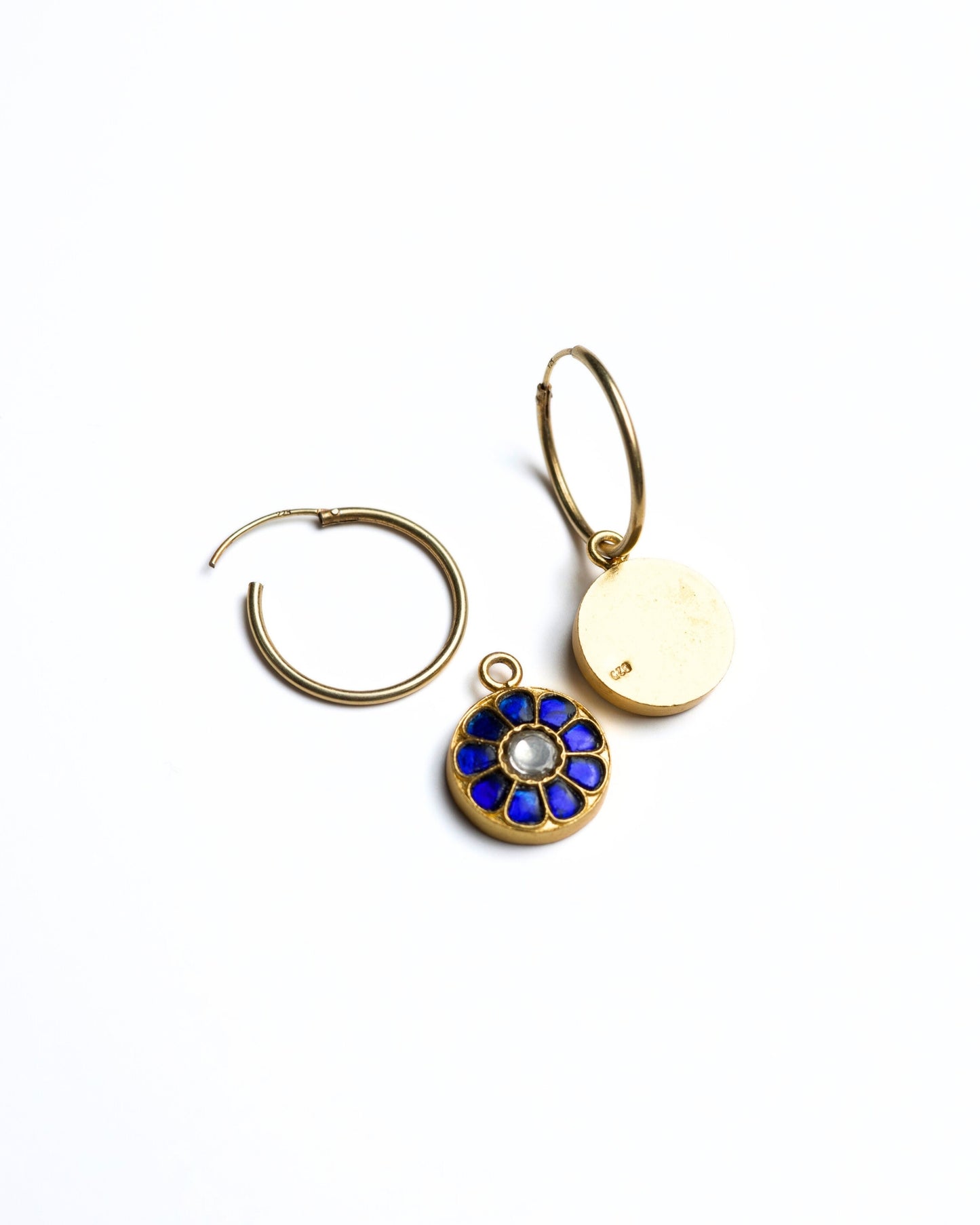 Close-up of small gold-polished 925 silver hoop earrings with deep blue lapis-style petal inlay and kundan stone centre.