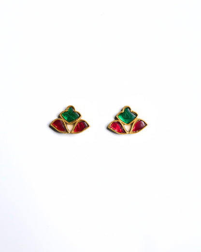 Close-up of red and green stone stud earrings in a fan-shaped mosaic design crafted in gold polished 925 silver.