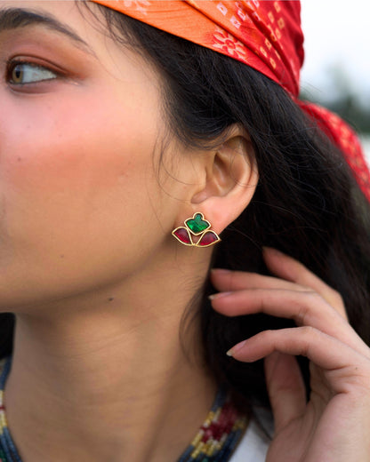 Close-up of red and green stone stud earrings in a fan-shaped mosaic design crafted in gold polished 925 silver.