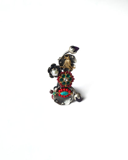 Front view of Ruby Gardenia Ascend Full Finger Ring in 925 silver, featuring a vertical garden-inspired composition with layered floral motifs, bird detailing, ruby-toned stones, and curved silver bands.