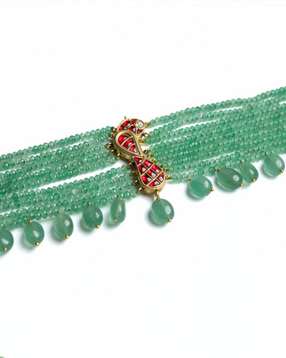 Green multi-strand beaded 925 silver choker with gold polish, red kundan-style bird motif at centre, and dangling green stone drops along the base.