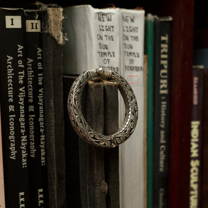 With winding vines nodding to the wisdom flowing through millenniums and the rustic dark finish of oxidised silver, this handcrafted engraved silver bangle comes with an adjustable toggle clasp. This bangle fits perfectly on your wrists and is durable and lightweight.