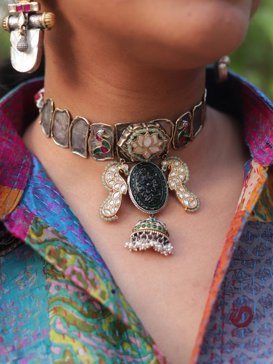 Close-up of Naksa's handcrafted Peacock Mirage Choker in 92.5 silver featuring lotus centrepiece, carved green stone, and kundan-set bird.