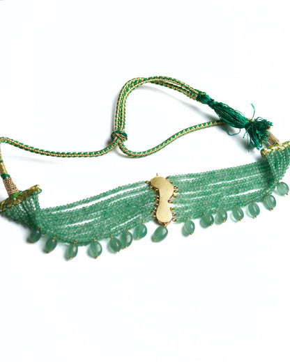 Green multi-strand beaded 925 silver choker with gold polish, red kundan-style bird motif at centre, and dangling green stone drops along the base.