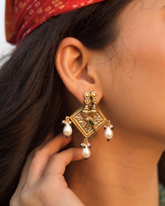 Gold polished 925 silver square earrings with twin heart detailing, green bird motif, and white pearl drop danglers.