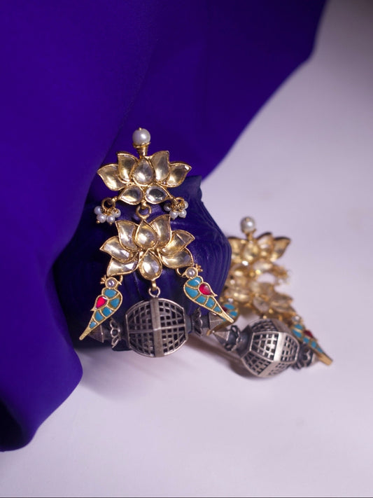 Close-up of handcrafted silver jhumkas with kundan lotus, colorful enamel parrots, and miniature silver dome inspired by jharokha windows – Naksa 92.5 silver earrings