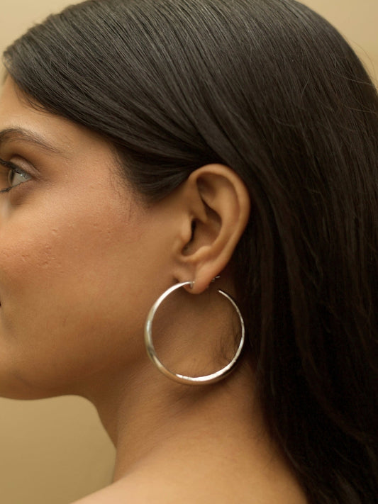 Hoops for Good earrings by Naksa—pure 925 silver classic hoop earrings with smooth finish, shown worn on ear.
