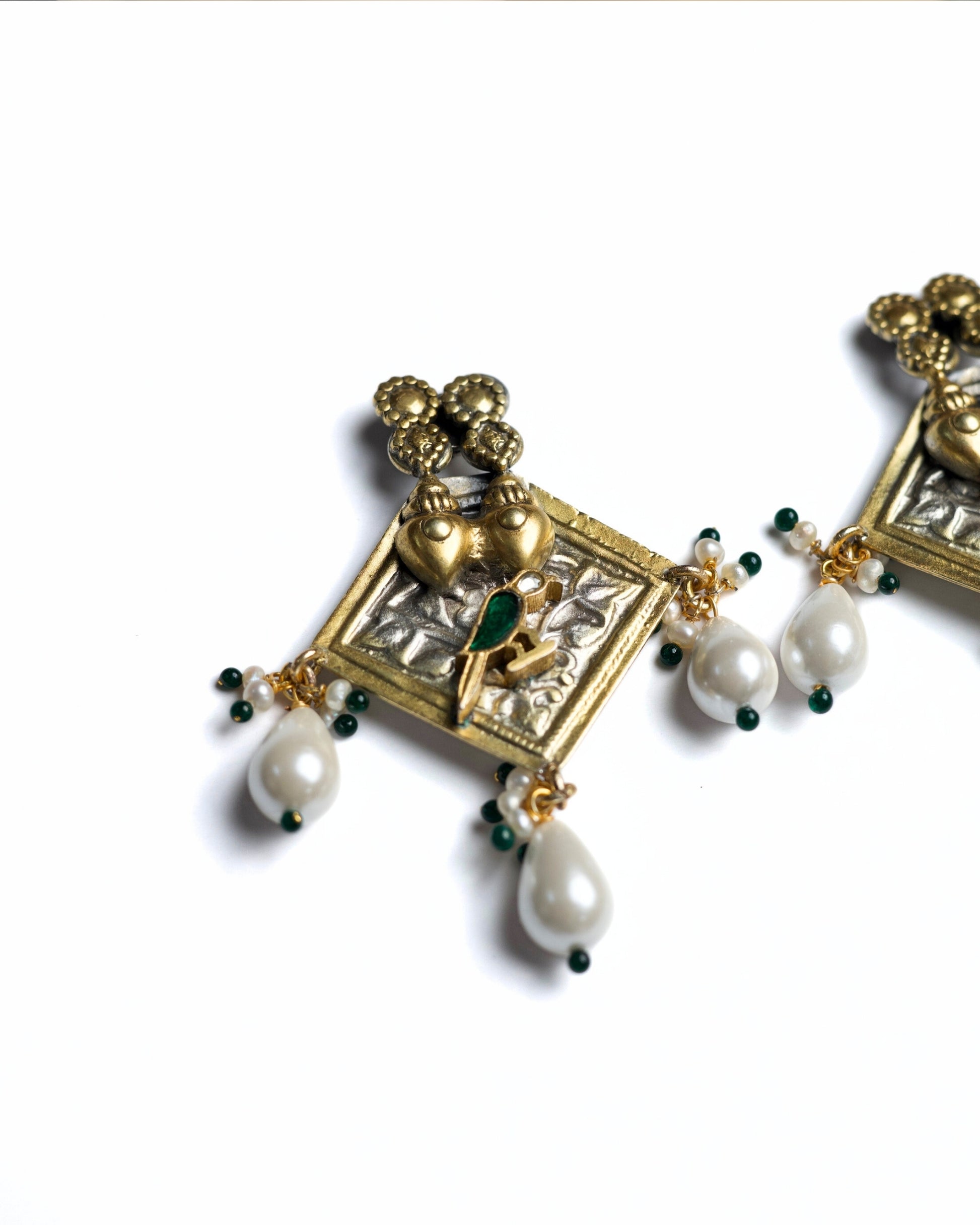 Gold polished 925 silver square earrings with twin heart detailing, green bird motif, and white pearl drop danglers.