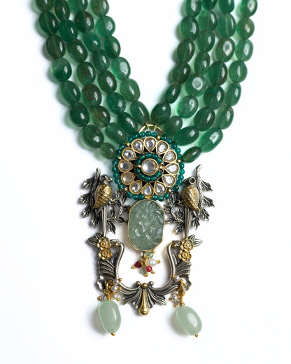Four-strand green jade bead necklace in 925 silver with gold-plated kundan floral centre, twin bird motifs, carved jade drop, and decorative hanging elements.