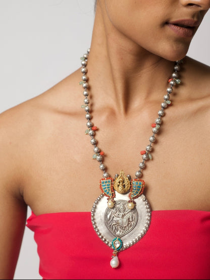 Antique silver Lakshmi pendant necklace with turquoise enamel tusk motifs, moonga and pearl accents, handcrafted in tribal style.