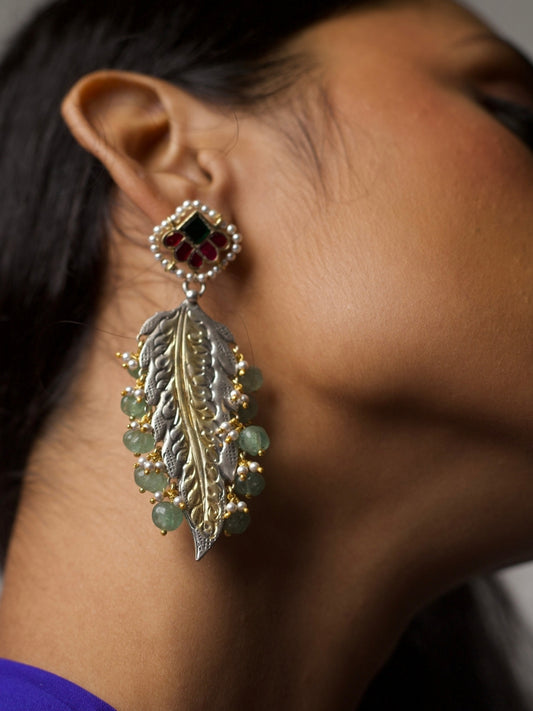 Close-up of Forest Muse Earrings in 92.5 silver with sculpted leaf design, gold accents, green stone drops, and kundan floral stud