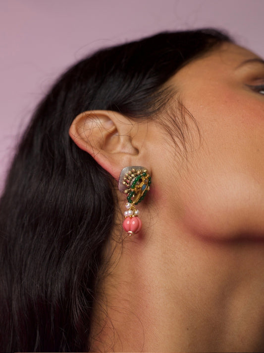 Close-up of Tiny Tales Earrings in 92.5 silver with gold accents, green enamel, pearl and coral pink bead drop