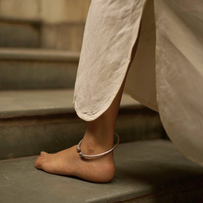 Two carved lionesses flank both sides of a sleek band etched with flowers and vines in this handcrafted traditional-modern silver anklet. This fusion of oxidised silver jewellery is an ode to the fierce spirit of women in the real and literary worlds.&nbsp;