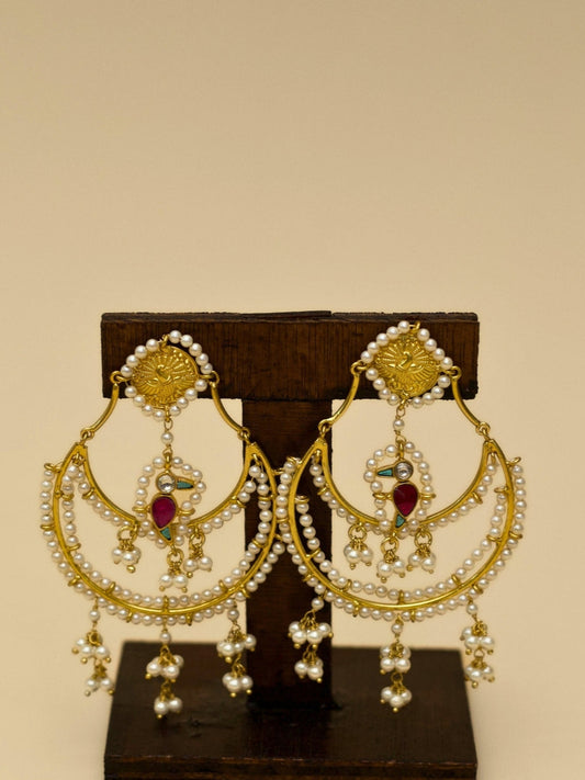 Nazaara Jhumkas by Naksa—gold polished 925 silver earrings with layered pearl crescents, kundan detailing, and a central parrot motif.