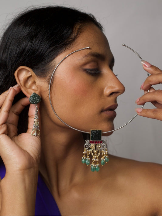 Model wearing Naksa’s Emerald Soirée Torque Set in 92.5 silver, featuring carved green stones and architectural forms in a collar-style necklace with matching earrings.