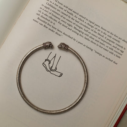 Two carved lionesses flank both sides of a sleek band etched with flowers and vines in this handcrafted traditional-modern silver anklet. This fusion of oxidised silver jewellery is an ode to the fierce spirit of women in the real and literary worlds.&nbsp;
