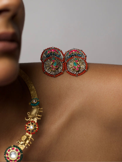 Close-up of The Tusker March Set – handcrafted 92.5 silver torque necklace with gold-plated elephant motifs and enamel detailing in red and green, styled with matching earrings.