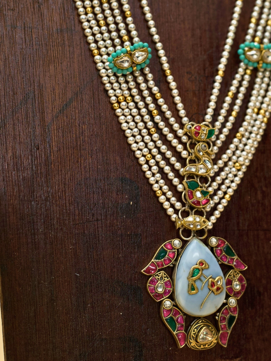 Kahaniyon Ki Maala by Naksa—multi-strand pearl haar in 925 silver with enamel tikras, hand-painted floral pendant, and miniature motif accents.