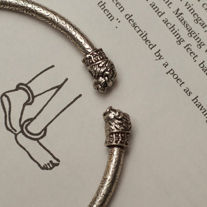 Two carved lionesses flank both sides of a sleek band etched with flowers and vines in this handcrafted traditional-modern silver anklet. This fusion of oxidised silver jewellery is an ode to the fierce spirit of women in the real and literary worlds.&nbsp;