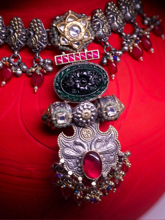 Close-up of The Garland Choker in 92.5 silver with red beads, temple-inspired details, and intricate golden accents