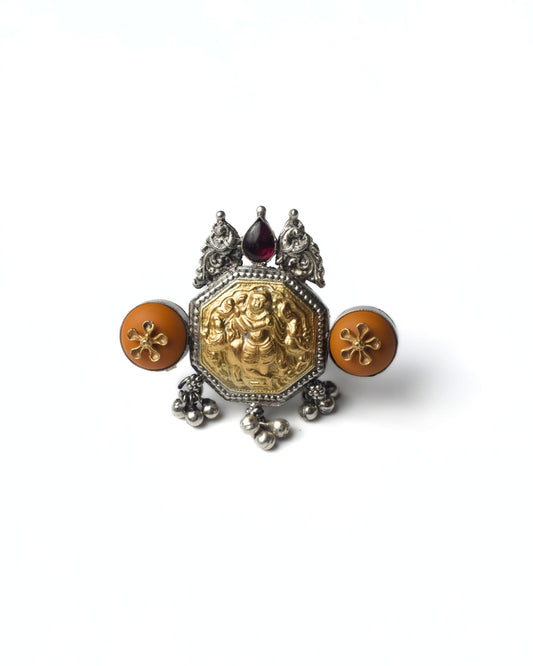 Devika Shield Ring in 925 silver with gold-toned goddess central relief, coral side discs, red stone crown, and silver drop detailing