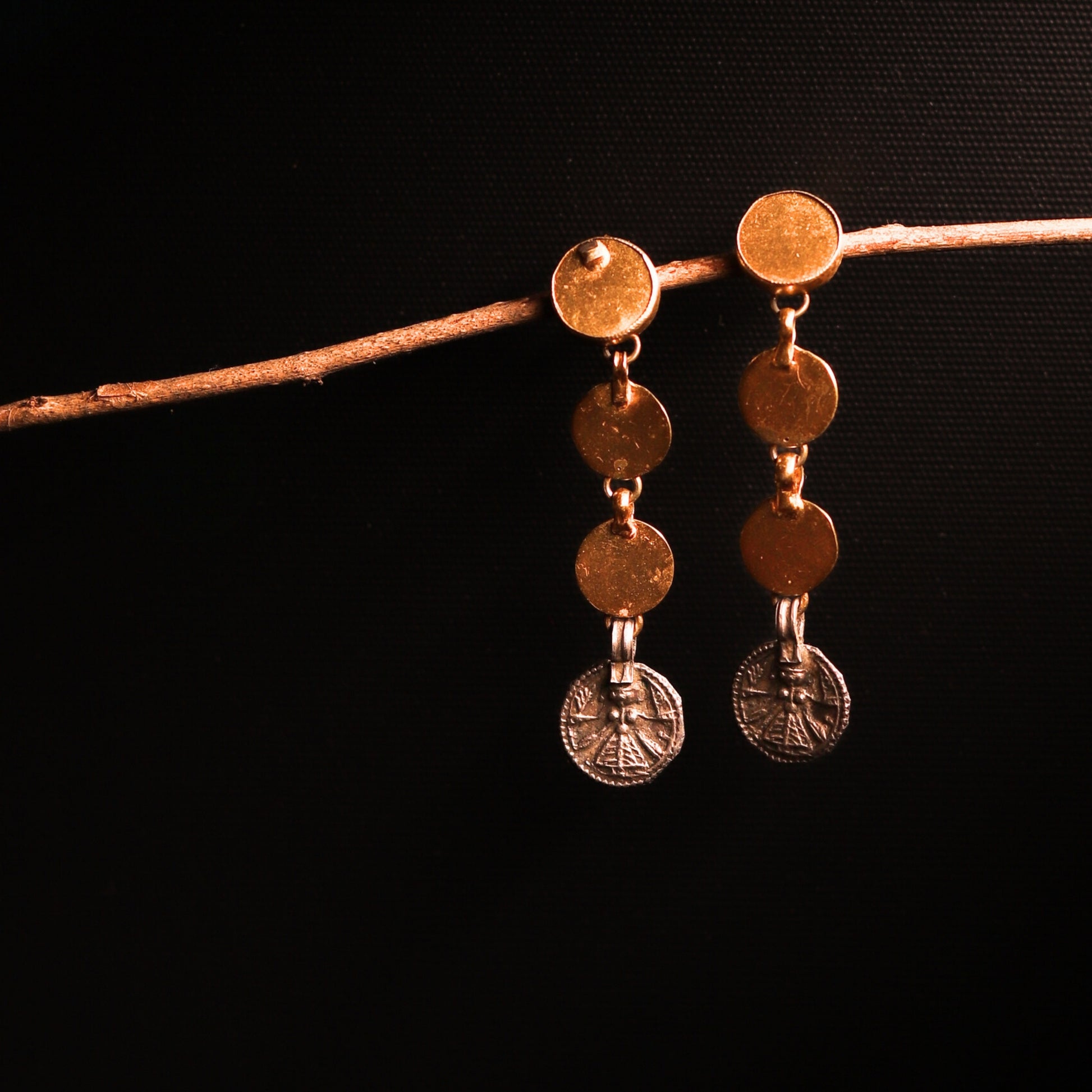 Minimal silver danglers featuring an antique coin embossed with Goddess Durga, paired with three gold-polished silver coins for a modern, chic design.