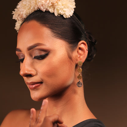 Minimal silver danglers featuring an antique coin embossed with Goddess Durga, paired with three gold-polished silver coins for a modern, chic design.