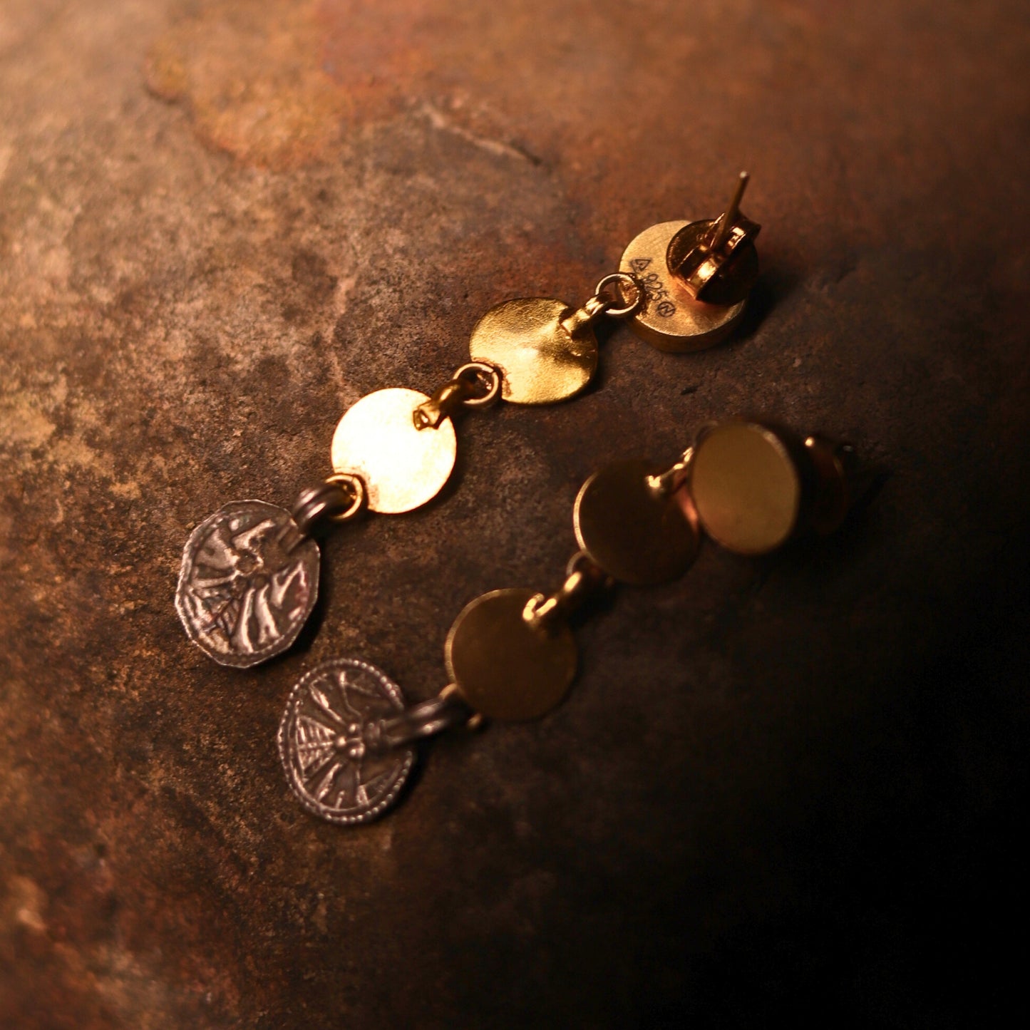 Minimal silver danglers featuring an antique coin embossed with Goddess Durga, paired with three gold-polished silver coins for a modern, chic design.