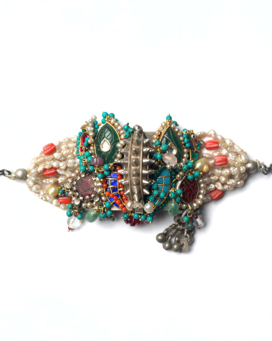 Central Relic bracelet cum choker in 925 silver featuring a sculpted silver spine, kundan teardrop motifs, pearl strands, and green stone detailing