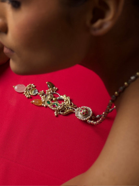 Handcrafted silver necklace with bird motifs, gemstone drops, and temple-style detailing in fusion design
