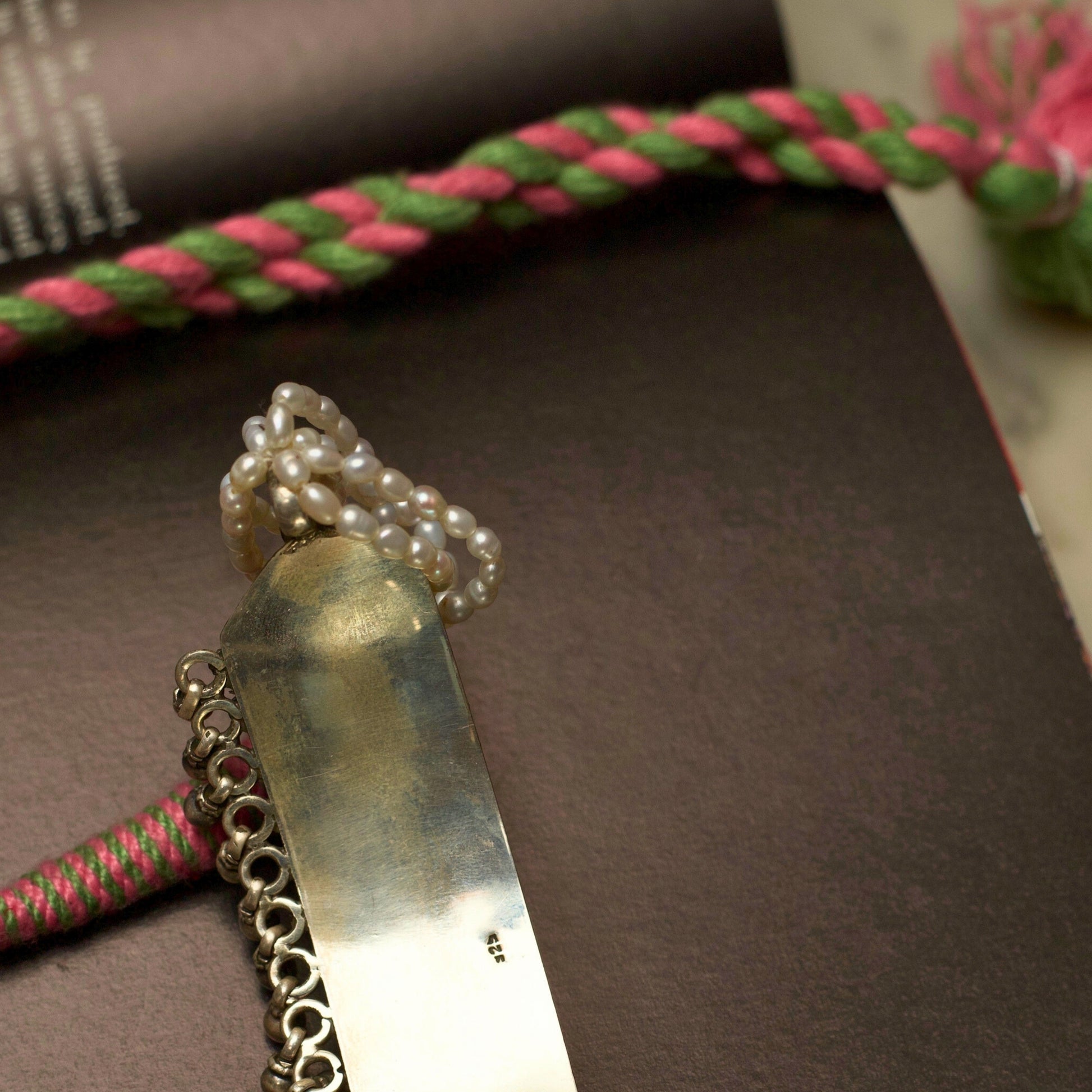 Light in weight but heavy on details, this piece creates the perfect balance by combining the dark patina of oxidised silver with pearly whites. The embossed and pastel-coloured flowers are a visual feast accentuated by the dangling ghunghroo beads. Style this with any outfit and flaunt your true spirit.&nbsp;