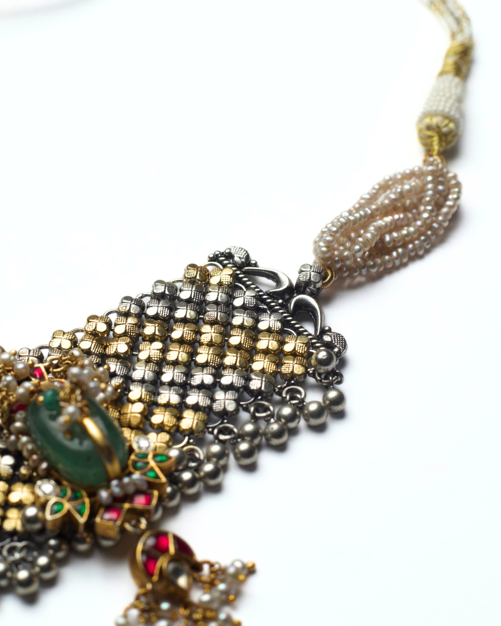 Handcrafted dual-tone lattice jaali work with emerald green stone centre