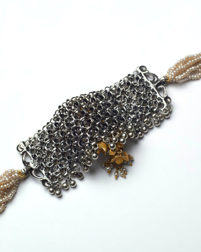 Back of dual-tone silver jaali choker with central green stone and pink kundan droplet detailing