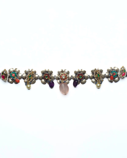 Floral silver choker with kundan-set flower centres and pink stone drops arranged in a linear row
