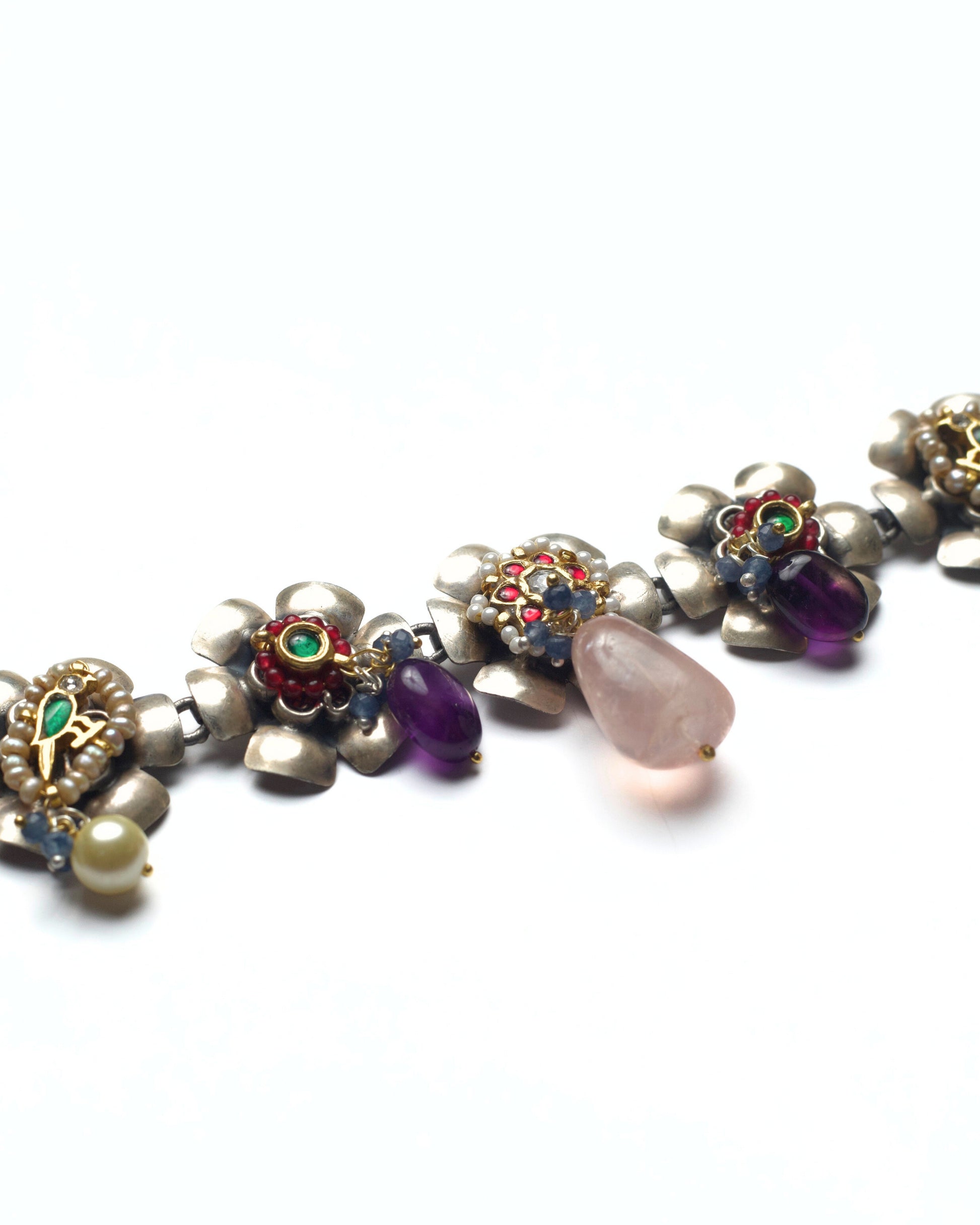 Silver choker showcasing multiple floral elements with kundan work and soft pink accents
