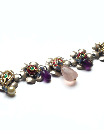 Silver choker showcasing multiple floral elements with kundan work and soft pink accents
