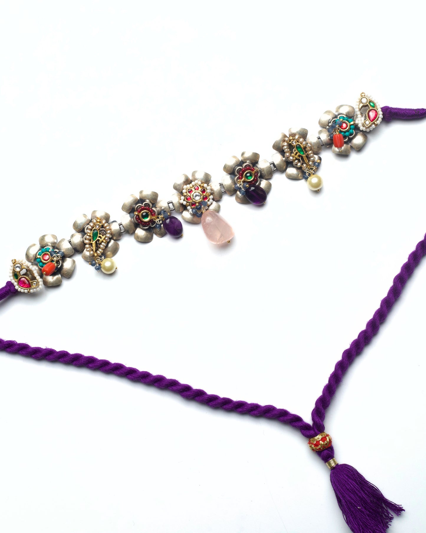 Floral silver choker with kundan-set flower centres and pink stone drops arranged in a linear row