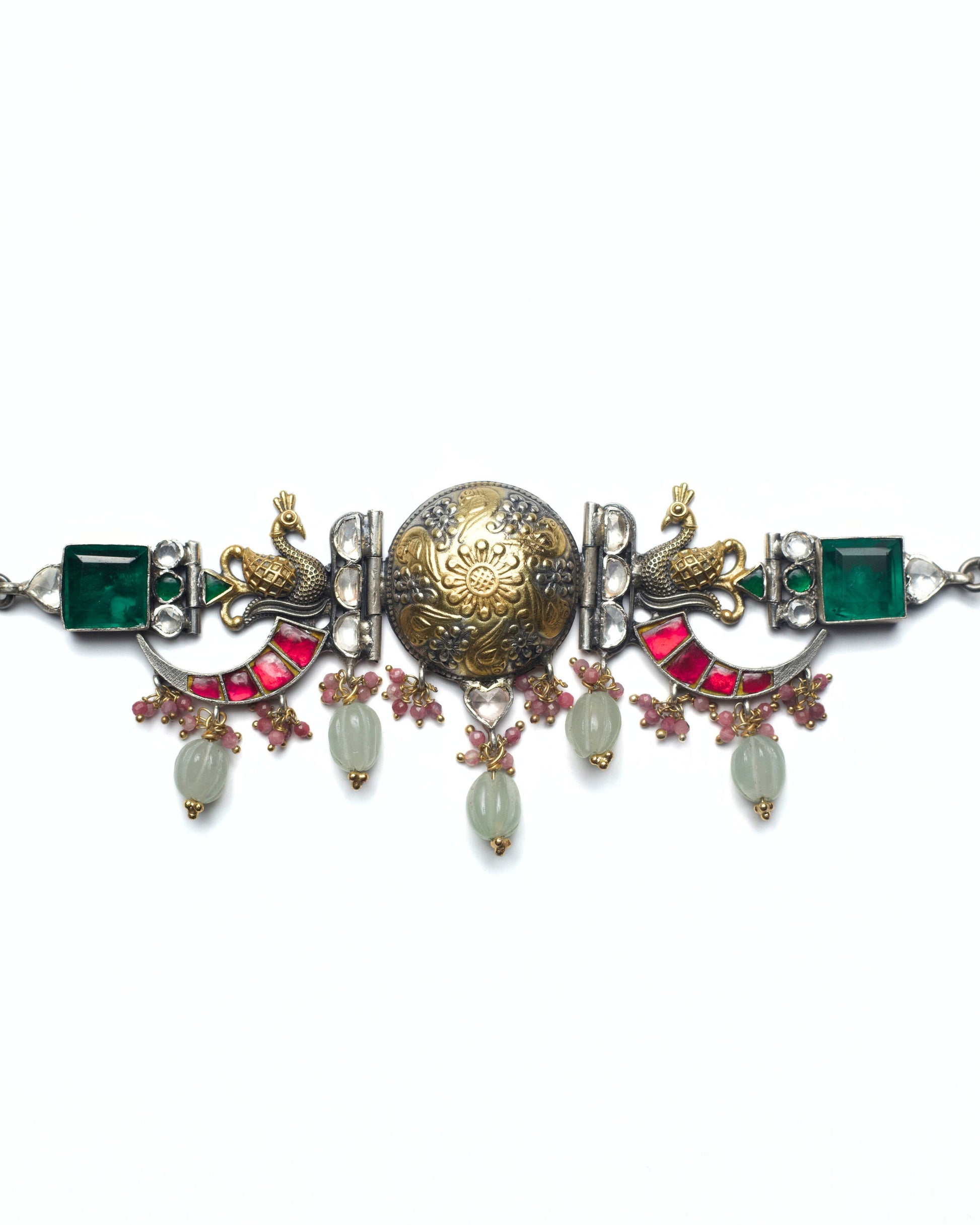 The Peacock Halo Choker in 925 silver featuring a dual-tone central medallion, sculpted peacock motifs, green stone highlights, pink stone arcs, and carved stone drops.