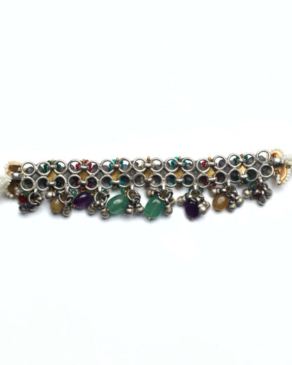 Back of oxidised silver rosette motifs with teardrop-shaped ruby red and emerald green kundan settings