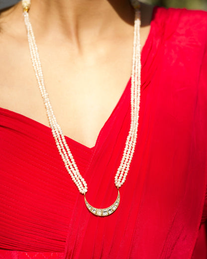 Crescent-shaped kundan pendant necklace with fine pearl strands