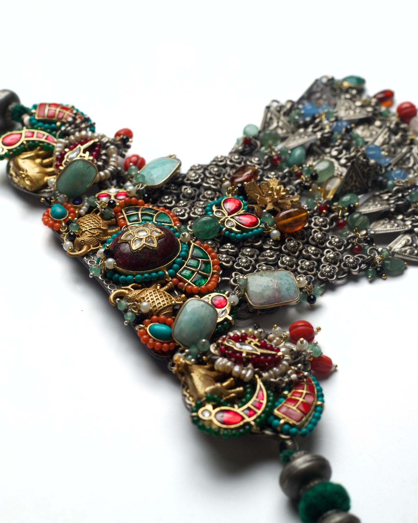 Top panel of fusion choker with turquoise and orange stones, sculpted elephant figures, tusk detailing, and central kundan setting